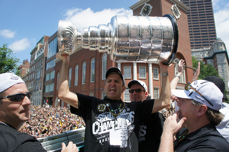 Dr. Thomas Gill holding the Stanley Cup trophy above his head during the Boston Bruins parade.